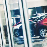 Used vehicles through showroom window.